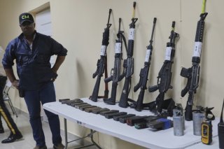A Port-au-Prince, la violence des gangs fait rage. Sur cette image prise au quartier général de la police de la capitale haîtienne les forces de l'ordre exhibent des armes confisquées aux gangs. KEYSTONE/AP/Odelyn Joseph